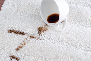 coffee stains on a white carpet with white mug.