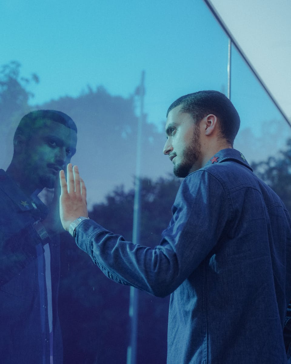 Young Man Reflecting in a Glass Wall